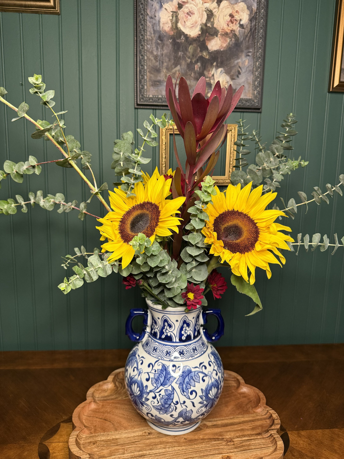Sunflowers and safari sunset with eucalyptus in a blue-and-white ceramic vase